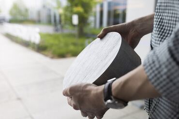 Uomo che tiene in mano un campione di billetta in alluminio