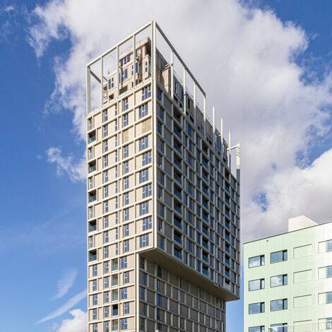 Edificio alto beige con numerose finestre, situato nel centro città.