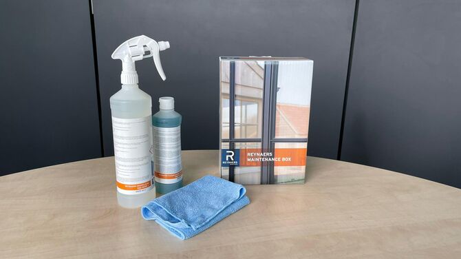 Reynaers Aluminium care products displayed on a wooden table.