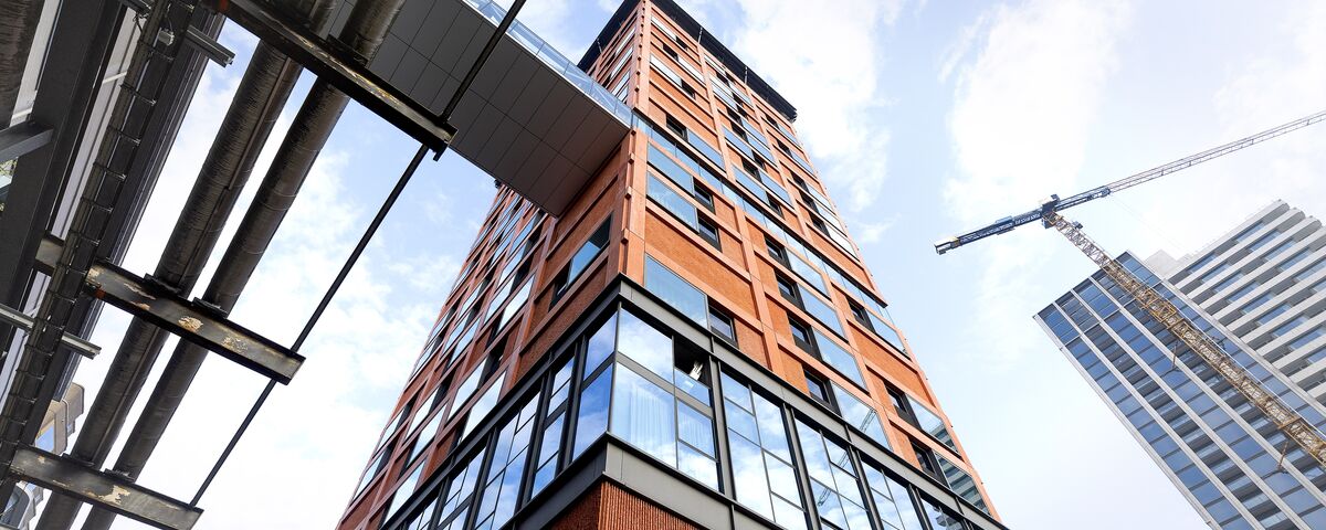 Edificio arancione di grande altezza visto dal basso. 