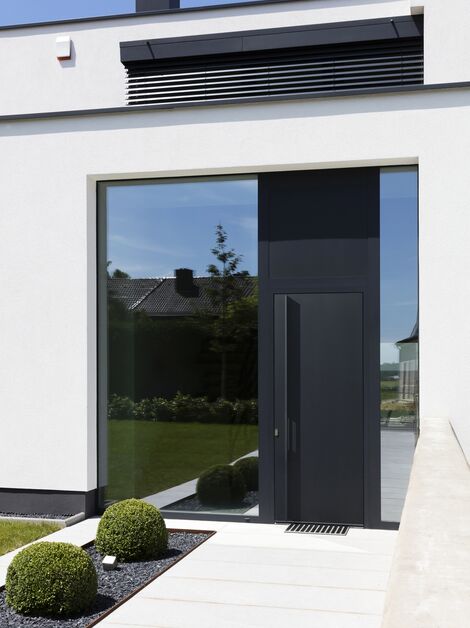 Casa moderna con porta a pannello in alluminio nero.
