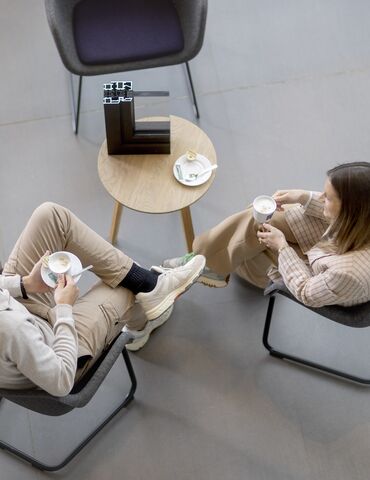 Vista dall'alto di uomo e donna seduti a un tavolo, bevendo caffè.