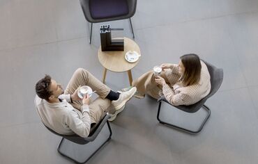 Vista dall’alto di un uomo e una donna seduti a un tavolo che bevono un caffè.