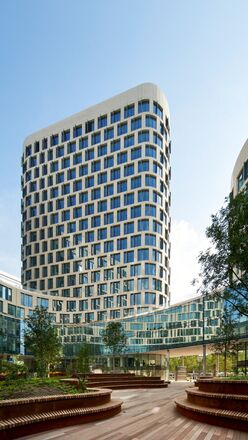 Edificio per uffici futuristico, bianco, con linee moderne e alberi adiacenti. 